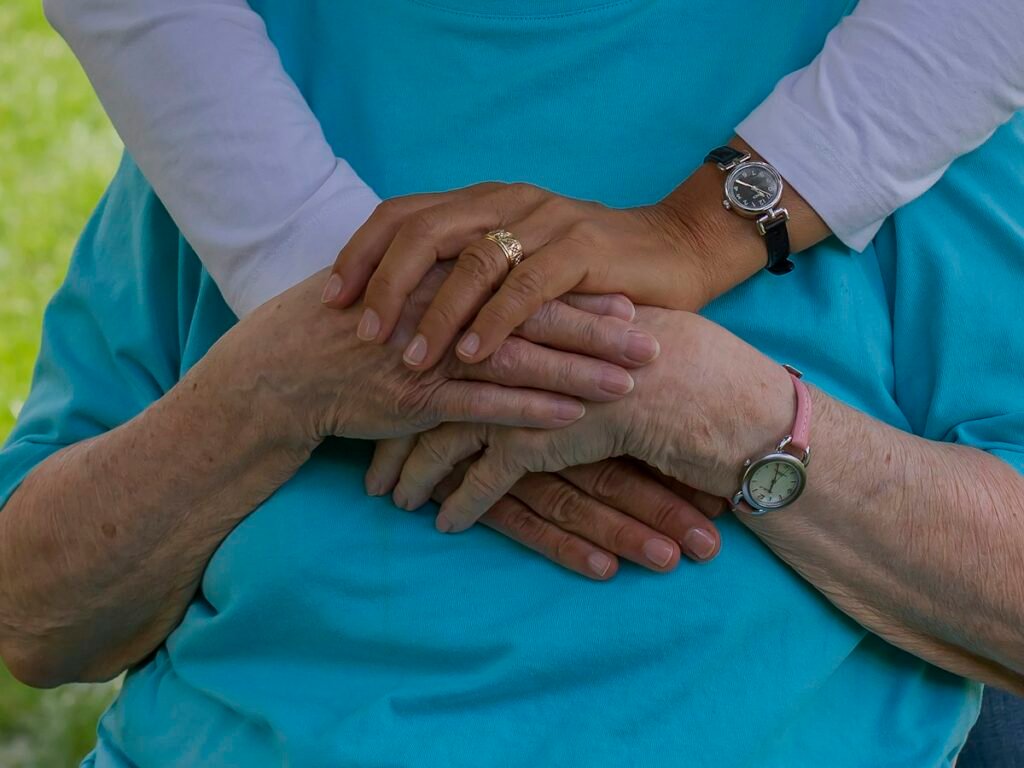 Caring hands holding the hands of an elderly loved one
